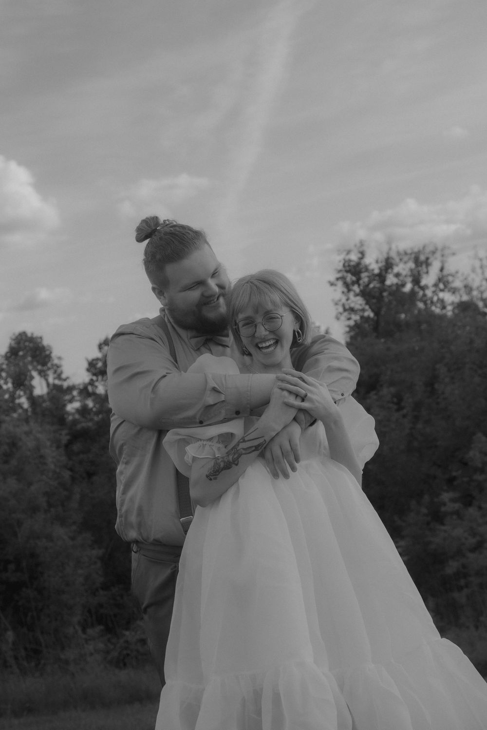 Black and white wedding photos showing intimate embraces in a natural setting.