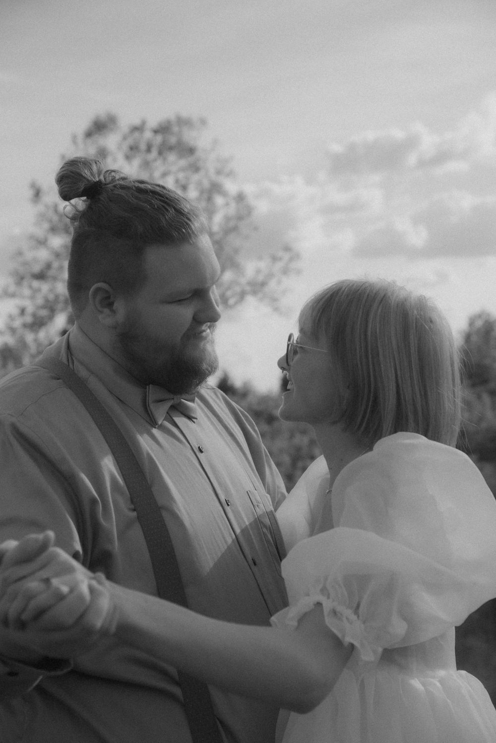 Artistic black and white wedding portraits capturing romantic moments outdoors.