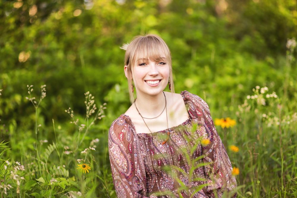 Candid senior photo at a lake cabin during sunset