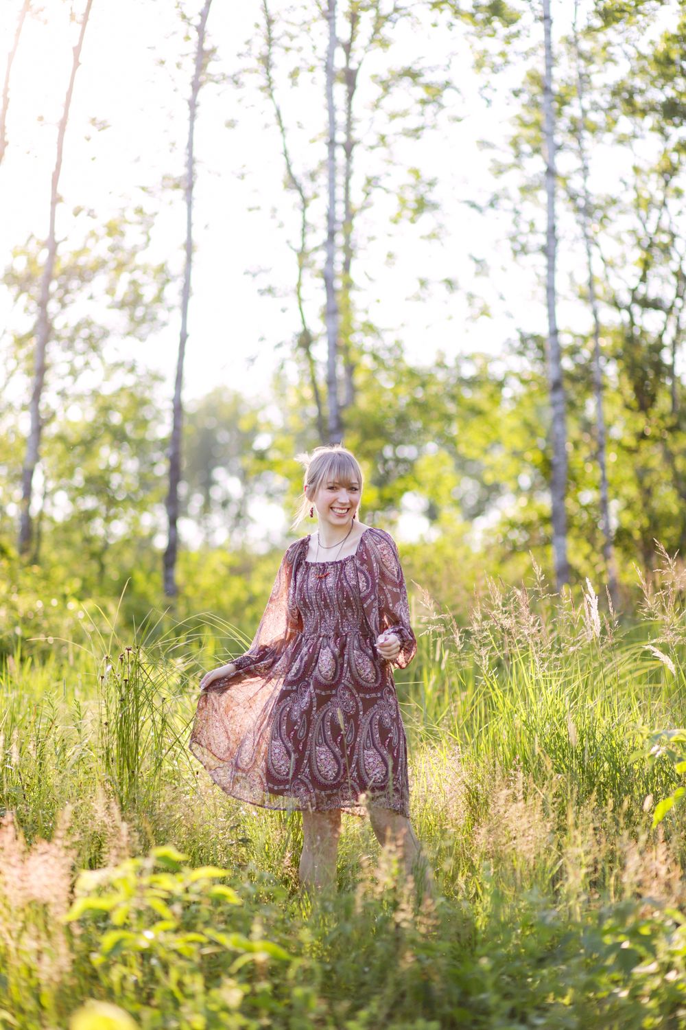 High school senior walking near a lake at their family cabin