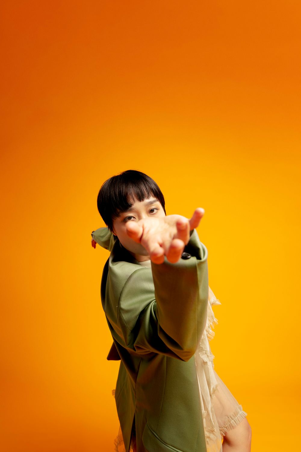 Person in white top performing dramatic poses against vibrant orange background in sequence.