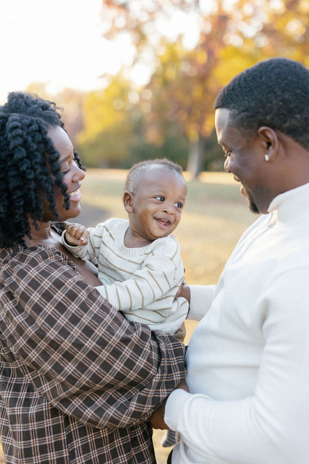 A joyful outdoor family photoshoot showing playful interactions against an autumn backdrop.
