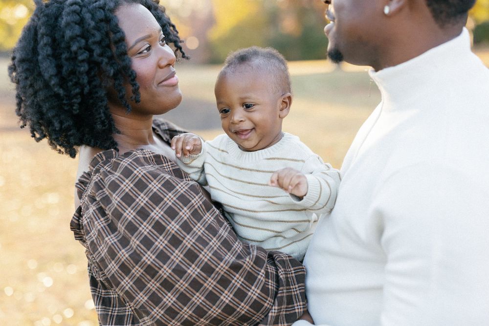 A family shares joyful moments together outdoors during a golden sunset photo session.