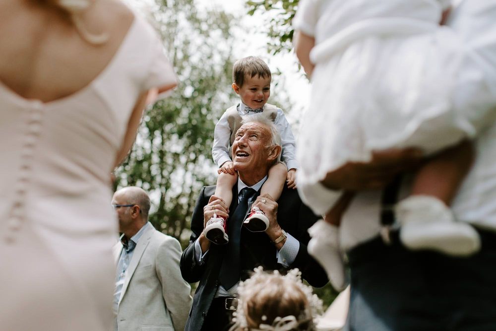 A series of black and white wedding photos showing candid moments between guests and wedding party members outdoors.