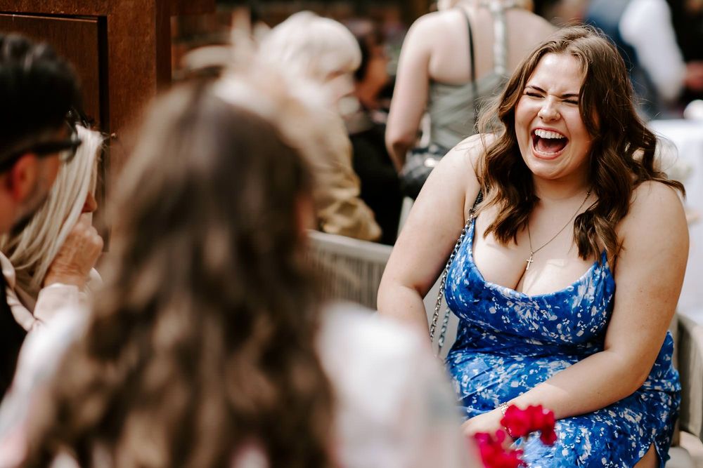 People dancing and celebrating at a lively party wearing blue floral dresses.