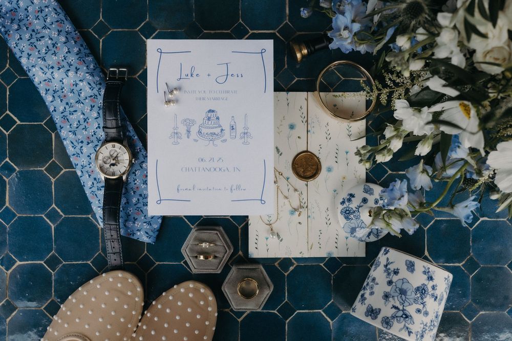 Wedding details and decorative signs arranged on a blue patterned surface.