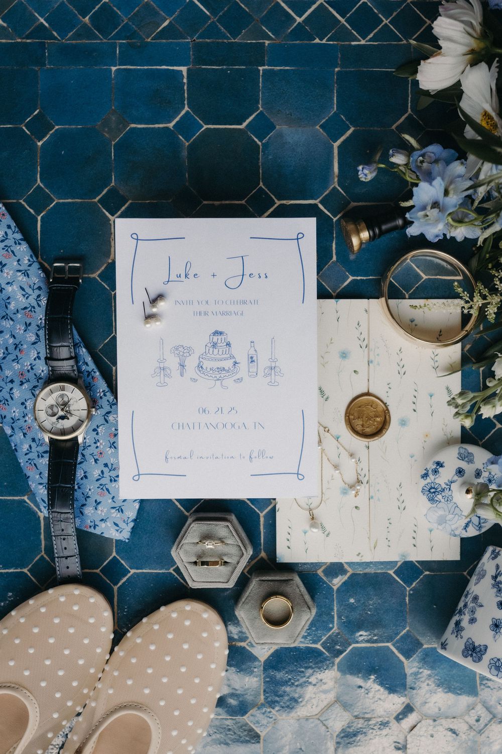 Wedding place cards and decorative elements arranged on blue tiled surface.