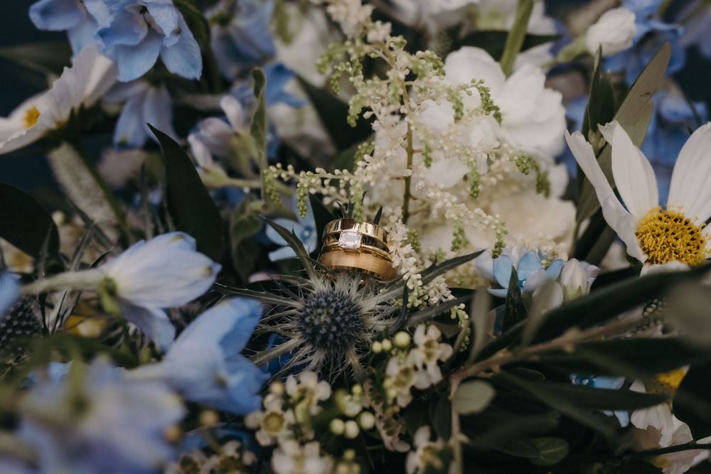 White and cream floral arrangements with delicate greenery against a dark background.