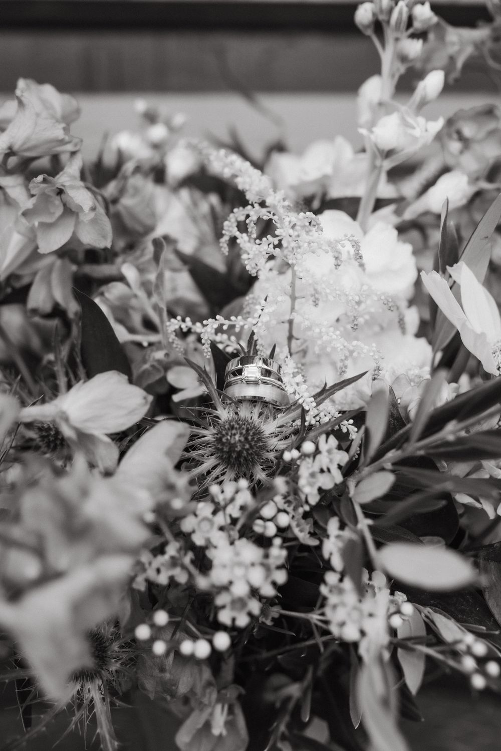 Black and white close-up of delicate floral arrangements with white blooms and greenery.