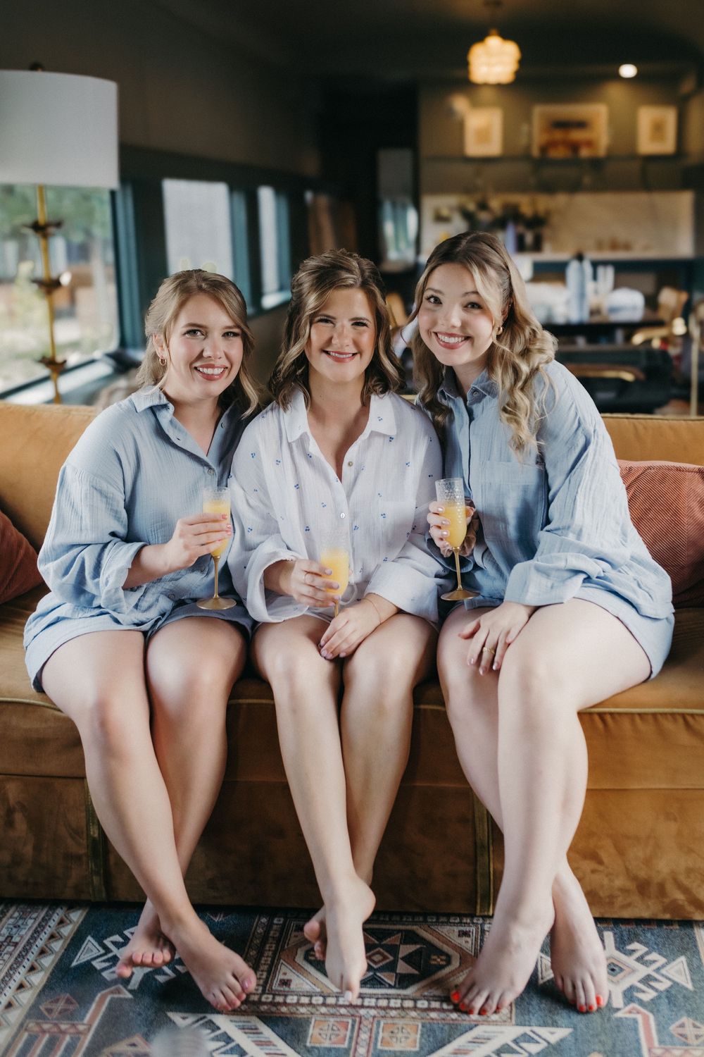 Group wearing matching light blue button-down shirts sitting together on a couch.