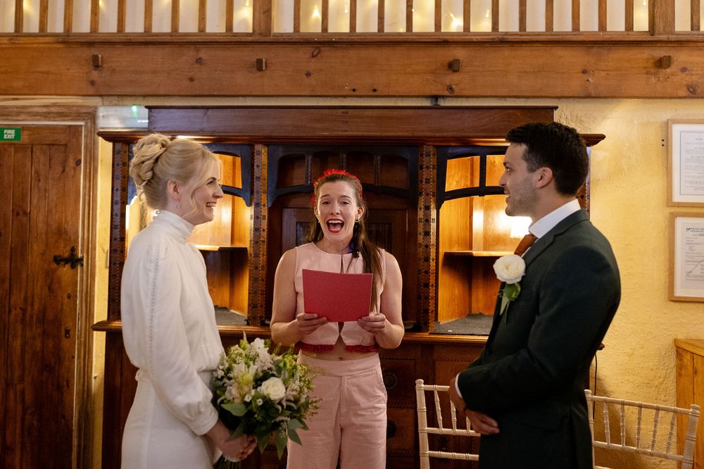Wedding celebration inside a rustic venue with wooden beams and intimate lighting.