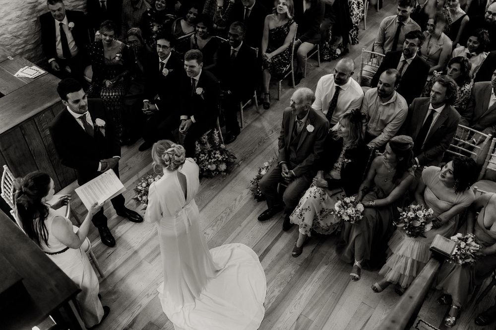 A black and white overhead view of wedding guests seated in rows during a ceremony.