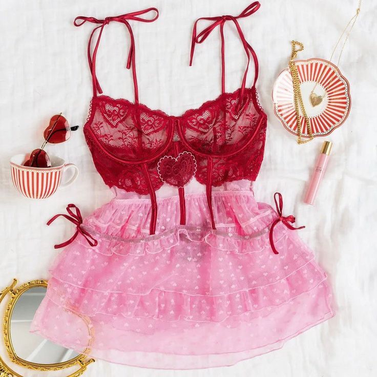 Pink lace lingerie bra and elastic band with 'LOUNGE' text against white fabric background.