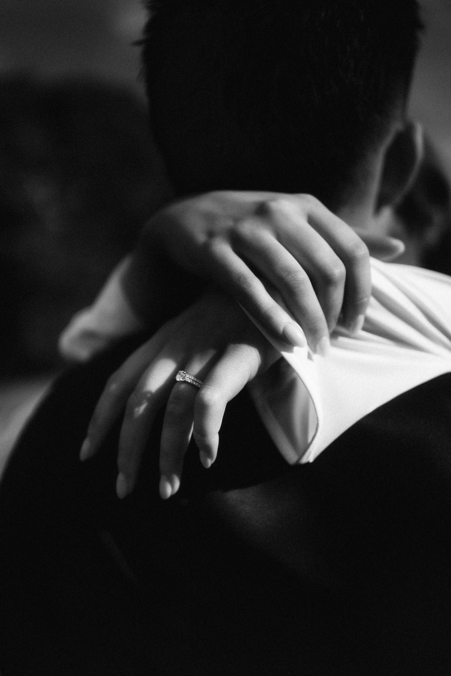 Black and white artistic sequence showing hands gently turning pages of a book in dramatic lighting at RJ Hamer, Olinda