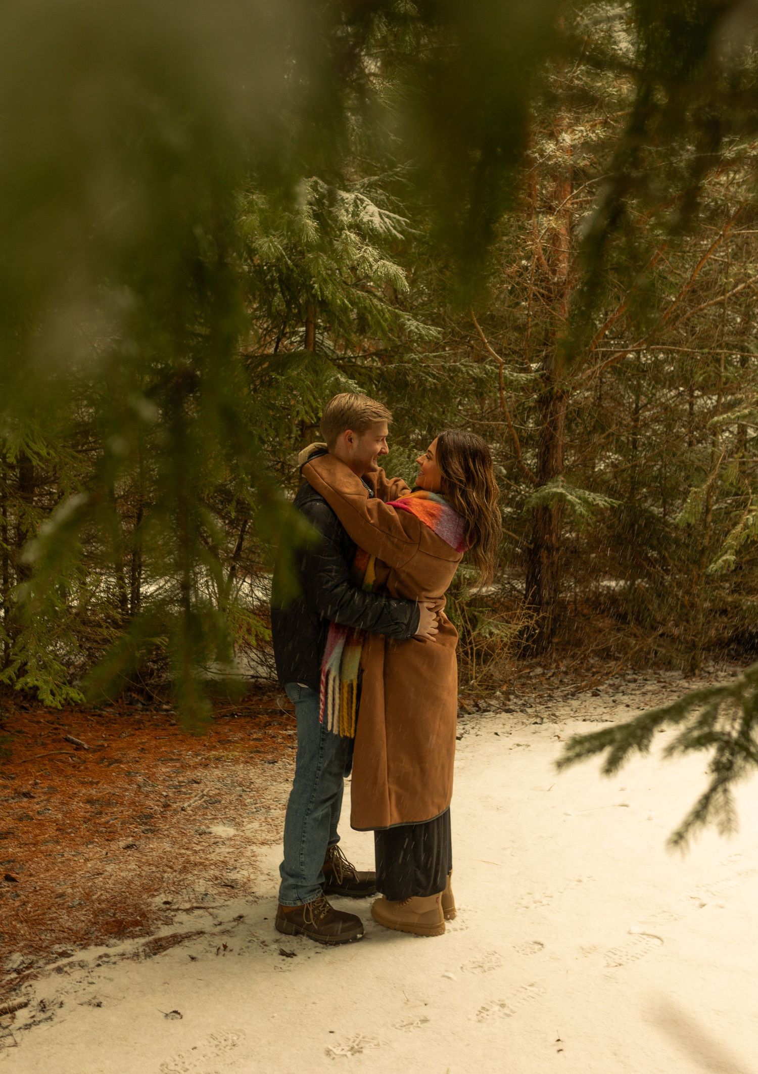 Two people share an intimate moment together in a snowy winter forest setting. Creative Art By Bree LLC