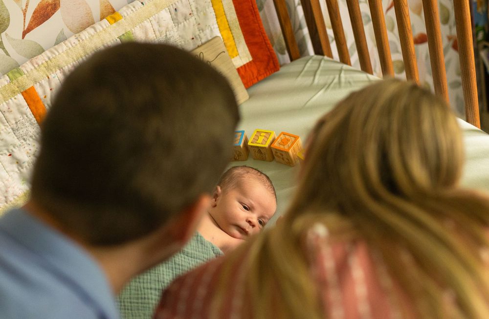 Soft natural light illuminates a nursery with alphabet blocks and bedding.