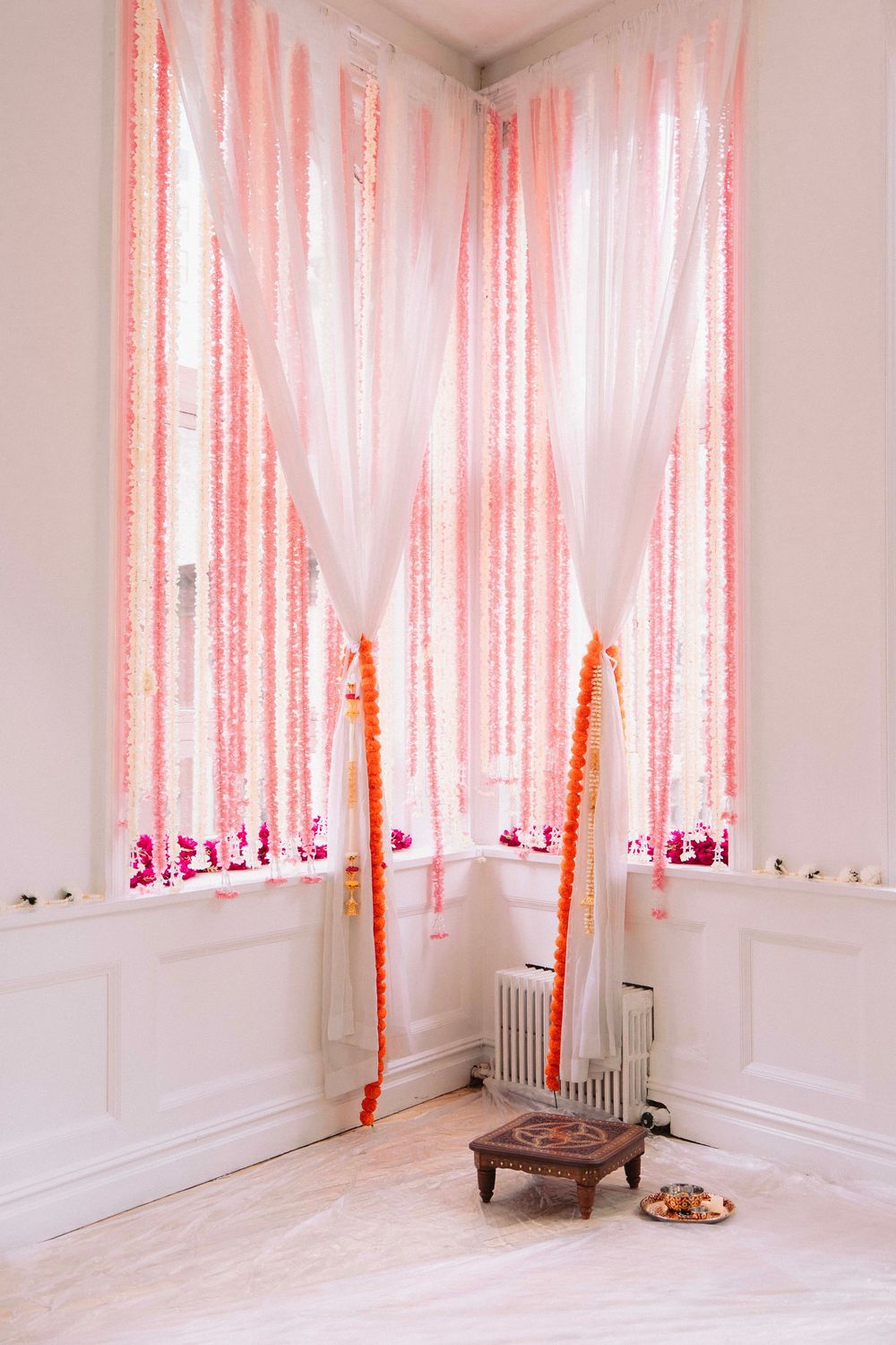 Pink and white streamers create dreamy backdrop in minimalist room interior.