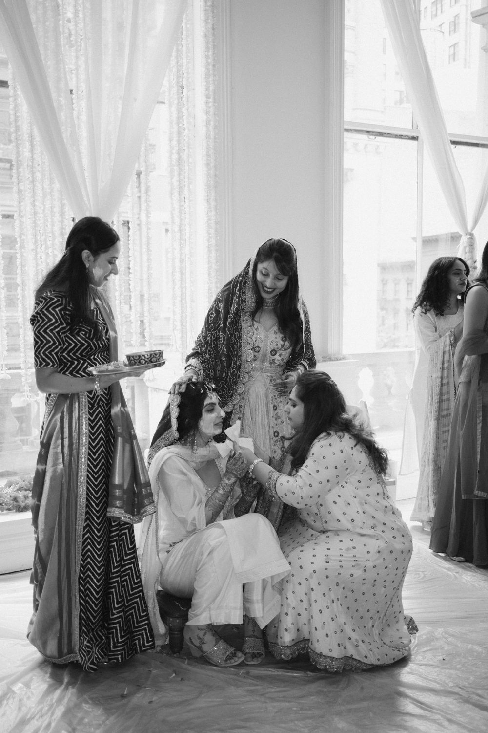 Black and white photos showing intimate moments during a traditional South Asian wedding ceremony.