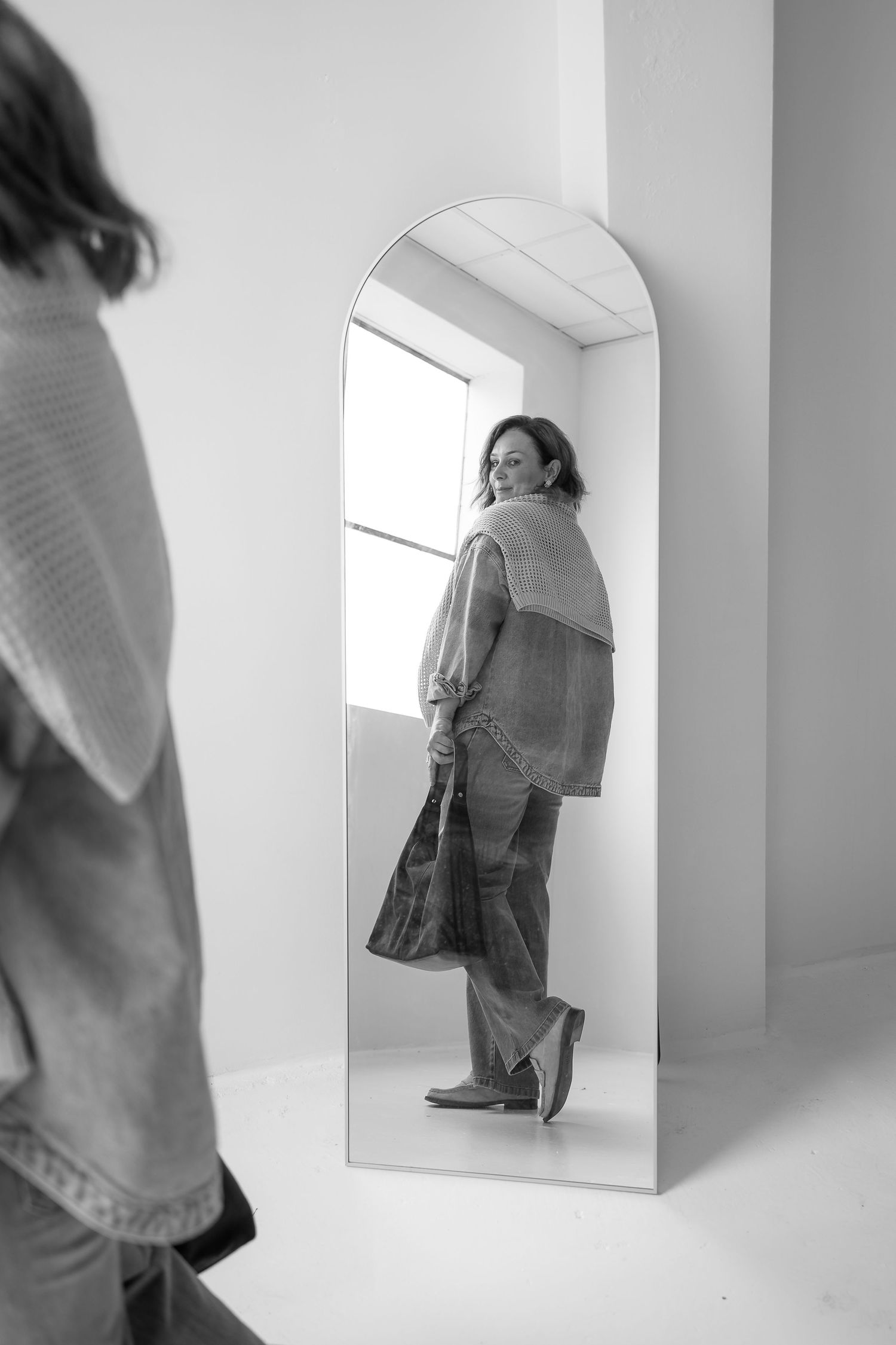 Artistic black and white photo series showing reflections and angles of person in white sweater.