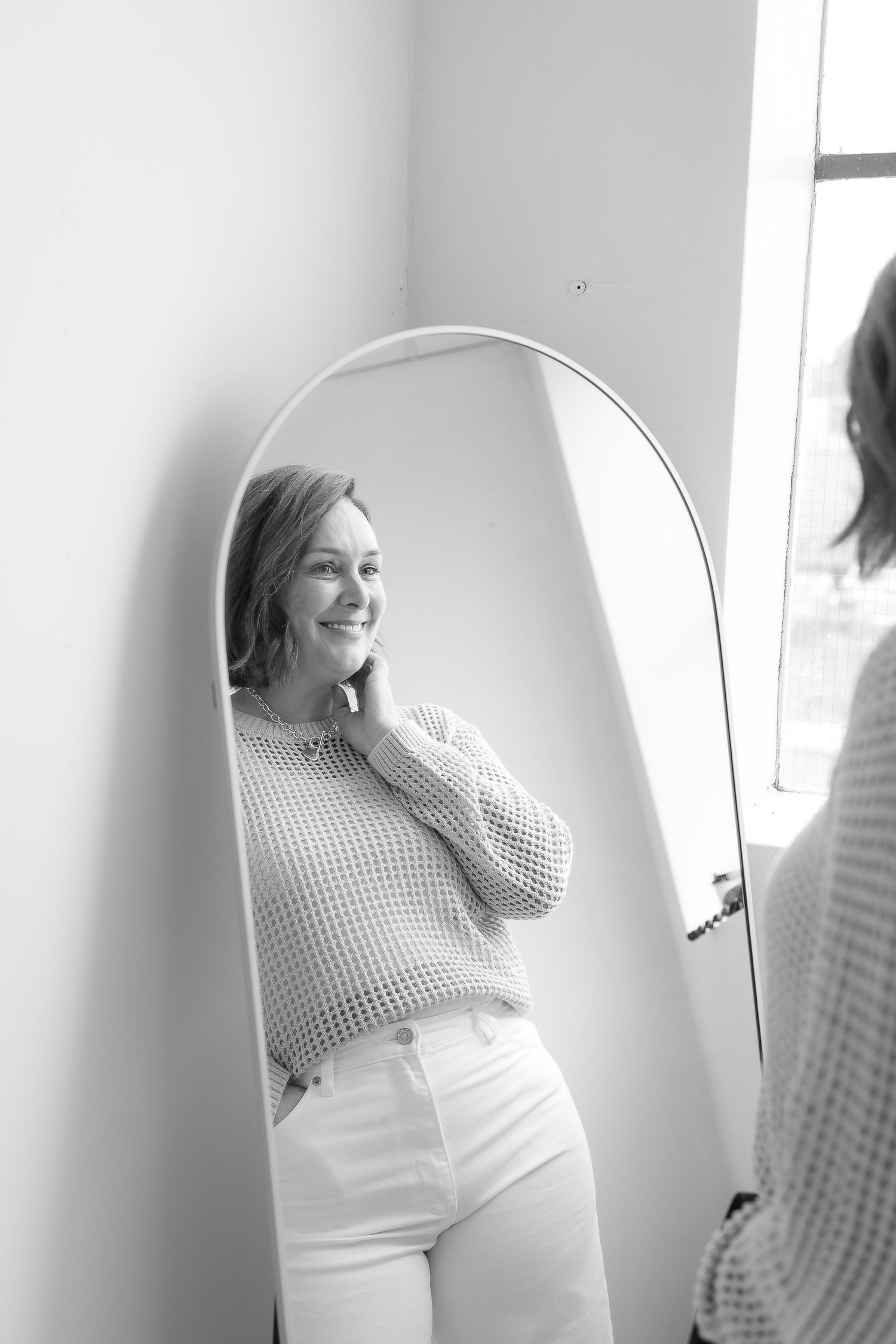 A sequence of black and white photos showing a person in a checkered top and white pants moving and laughing.