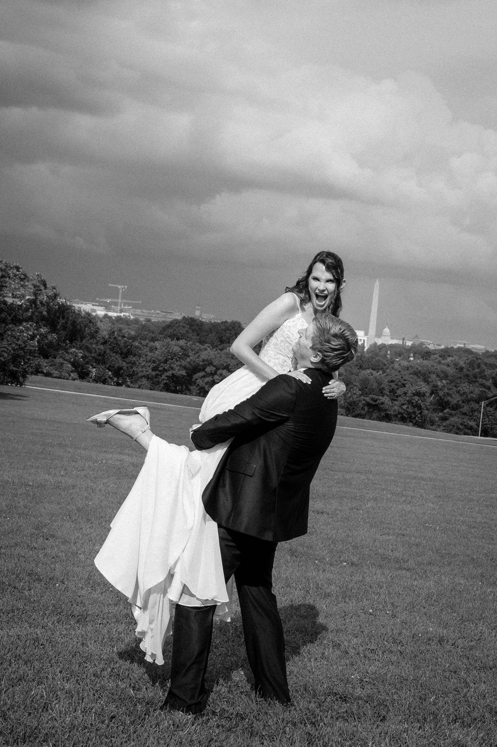 Black and white wedding photo sequence showing playful dip poses in an open grassy field with the Washington Monument seen in the background
