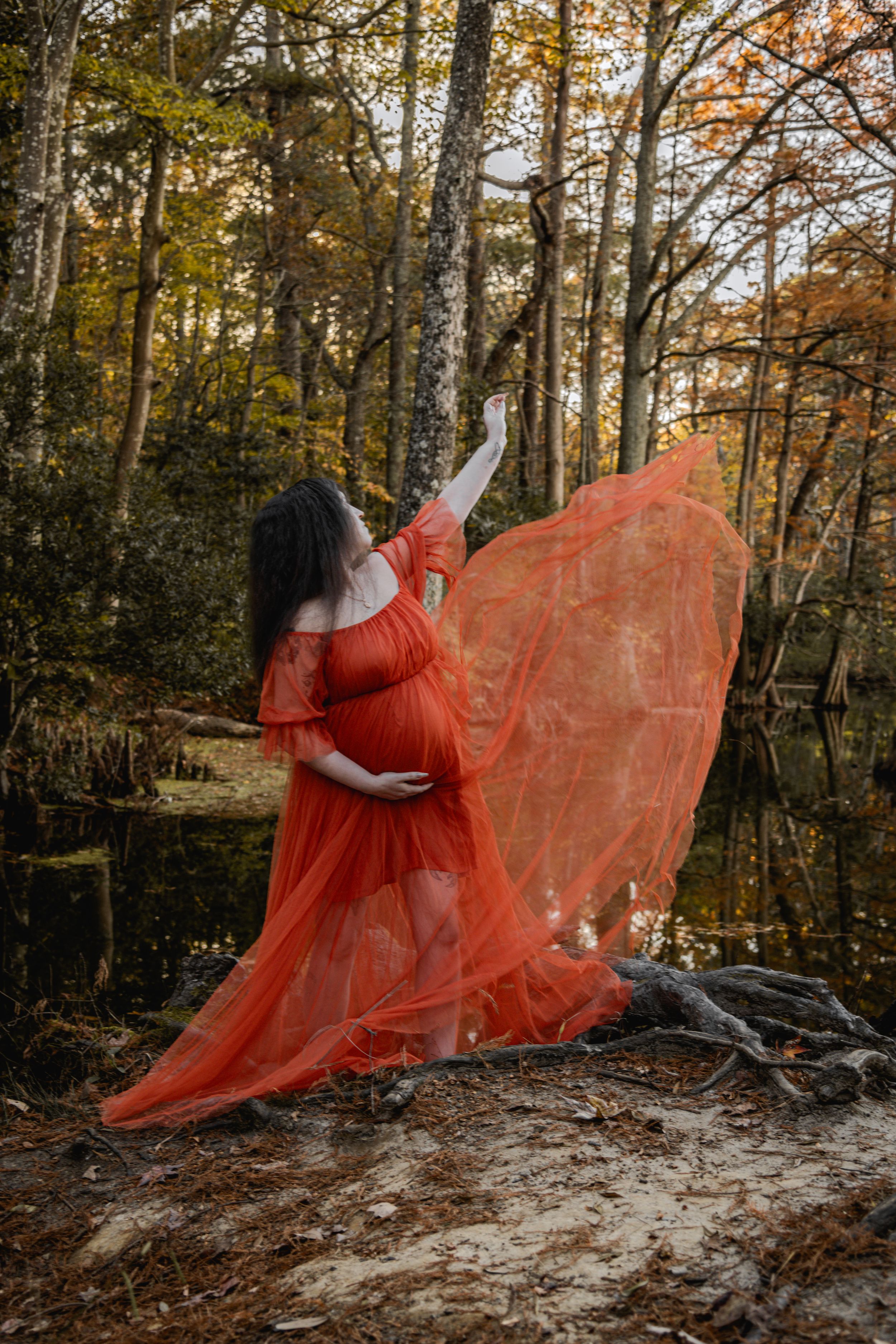A flowing red dress creates a dramatic silhouette against an autumn forest backdrop in a series of artistic photos.