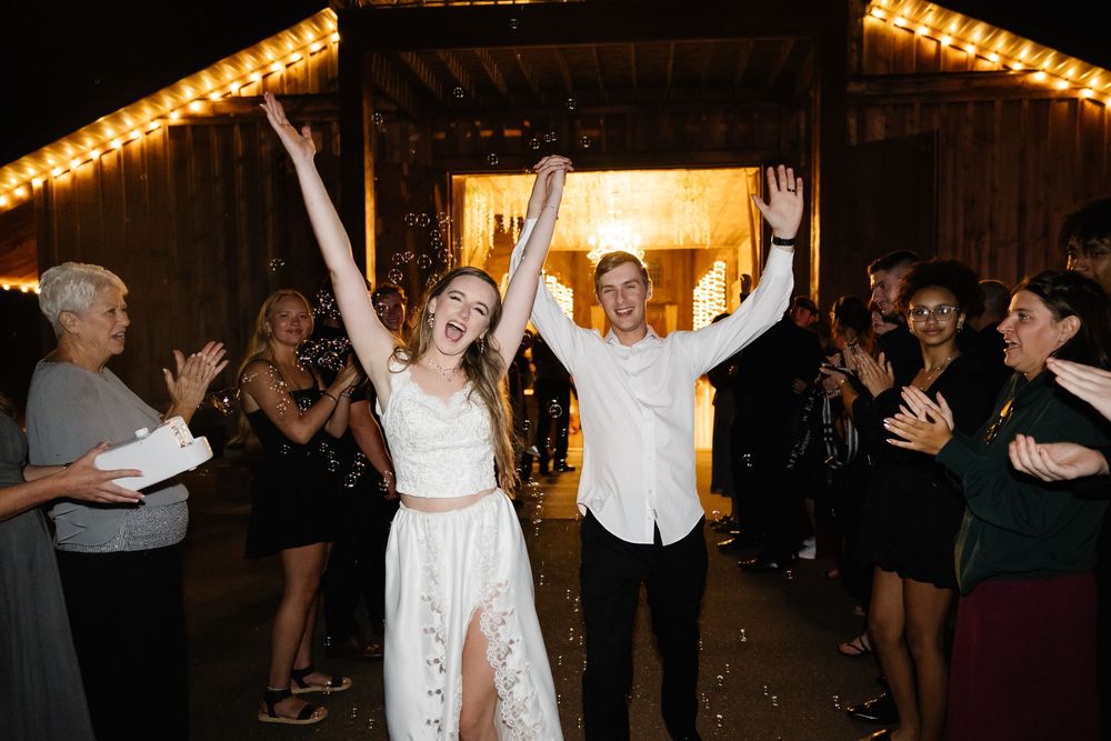 Wedding reception dance party with string lights and guests celebrating.