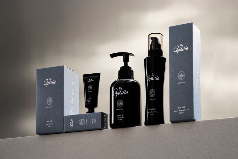 A collection of black luxury fragrance bottles and boxes arranged in a line against a white wall with dramatic lighting.