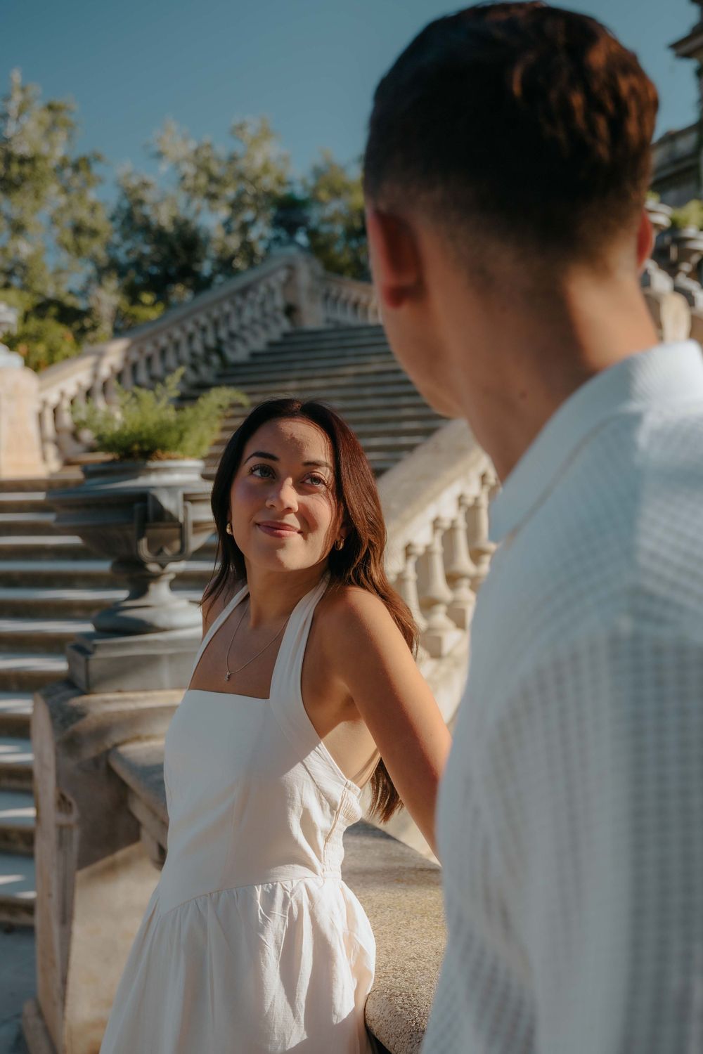 Wide shot of couple standing in front of historic fountain in Barcelona.