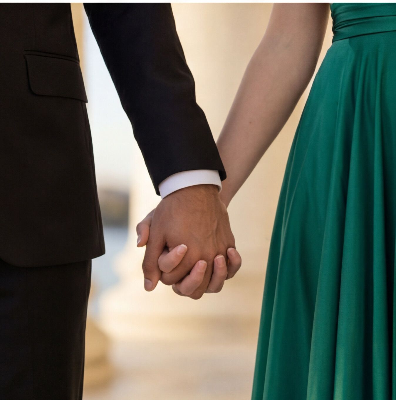 Close-up sequence of two people in formal wear holding hands, showing a black suit sleeve and emerald green dress. Flying Dress Photoshoot
