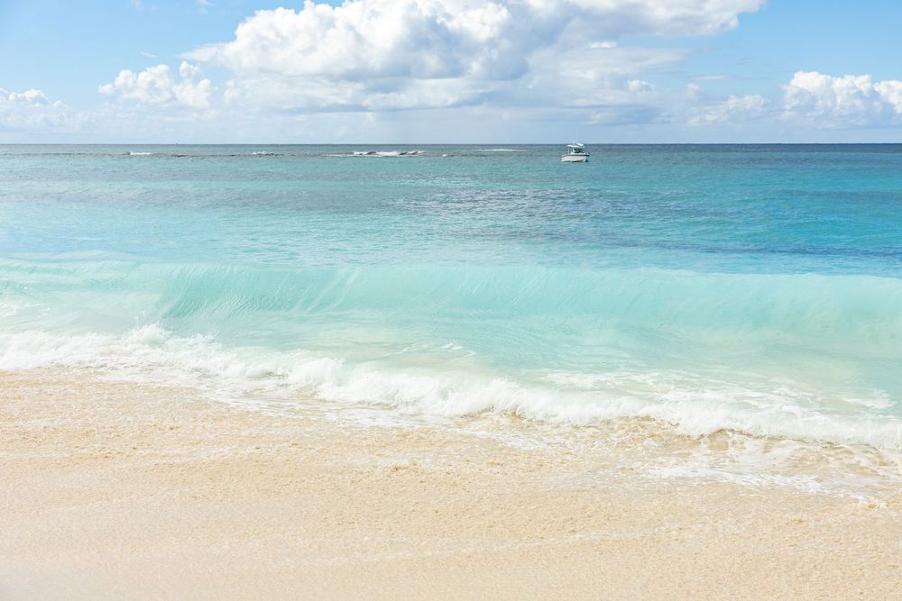 Panoramic view of a pristine tropical beach with turquoise waters and white sand stretching along the coastline on Shoal Beach Anguilla
