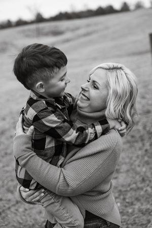 Black and white photo series showing tender moments between parent and child playing outdoors in casual sweaters.