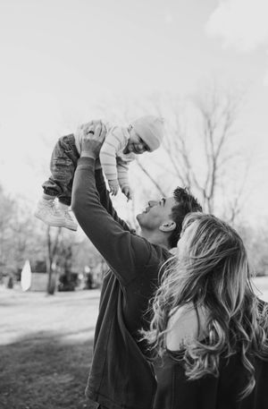 Black and white photo series showing someone joyfully playing with their pet dog outdoors in a park setting.