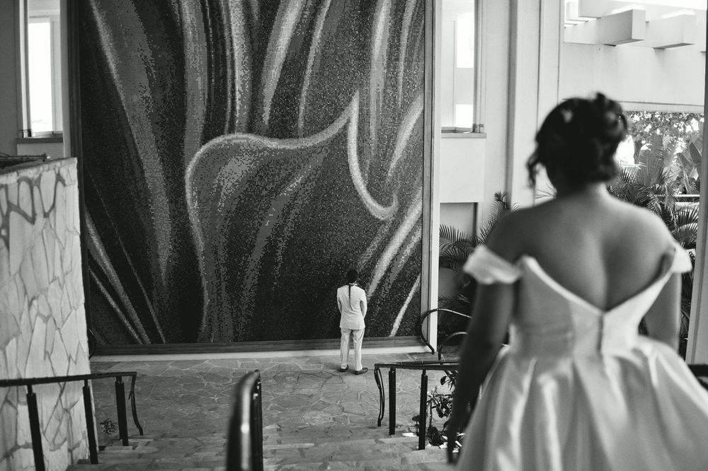 Black and white photo of a person walking down a narrow hallway with graffiti art covering the walls.