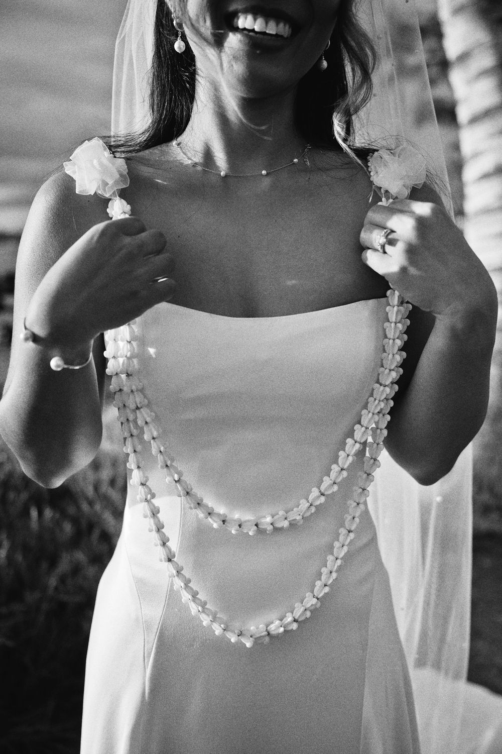 Black and white photo series showing a pearl necklace worn with a white dress in different cropped views.