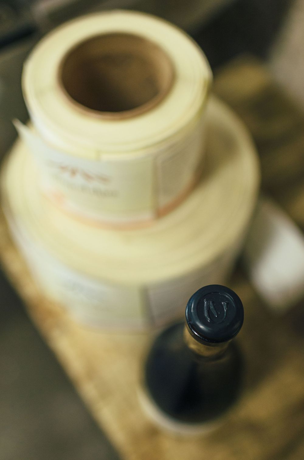 Collection of cream-colored ceramic containers and dark bottles arranged on a surface.