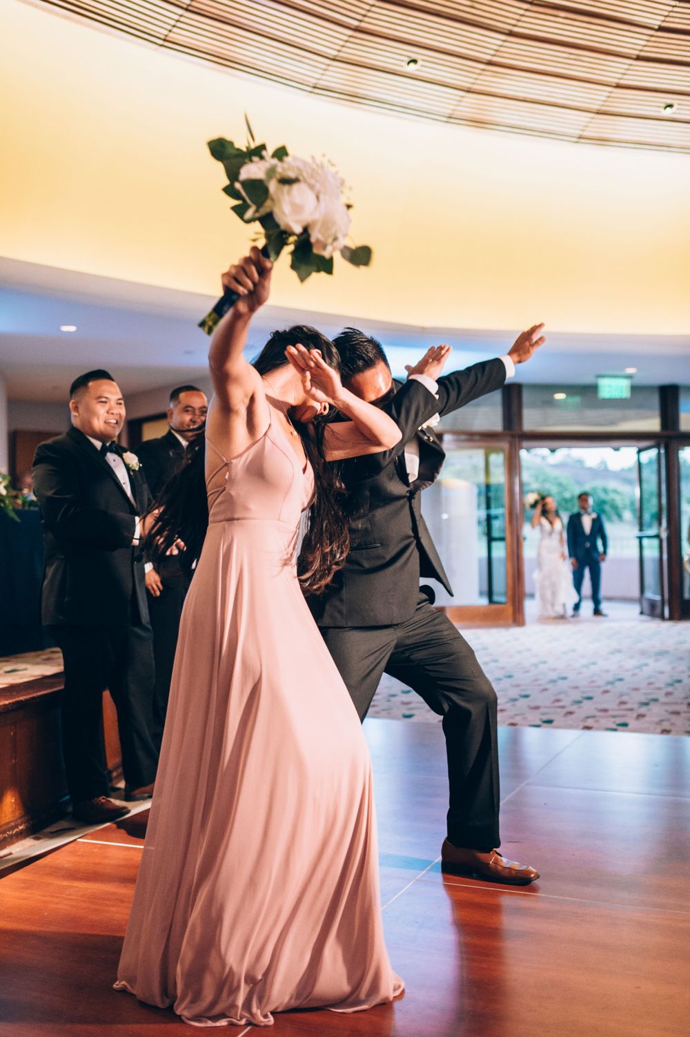 Wedding celebration with guests dancing and enjoying festivities in elegant venue.