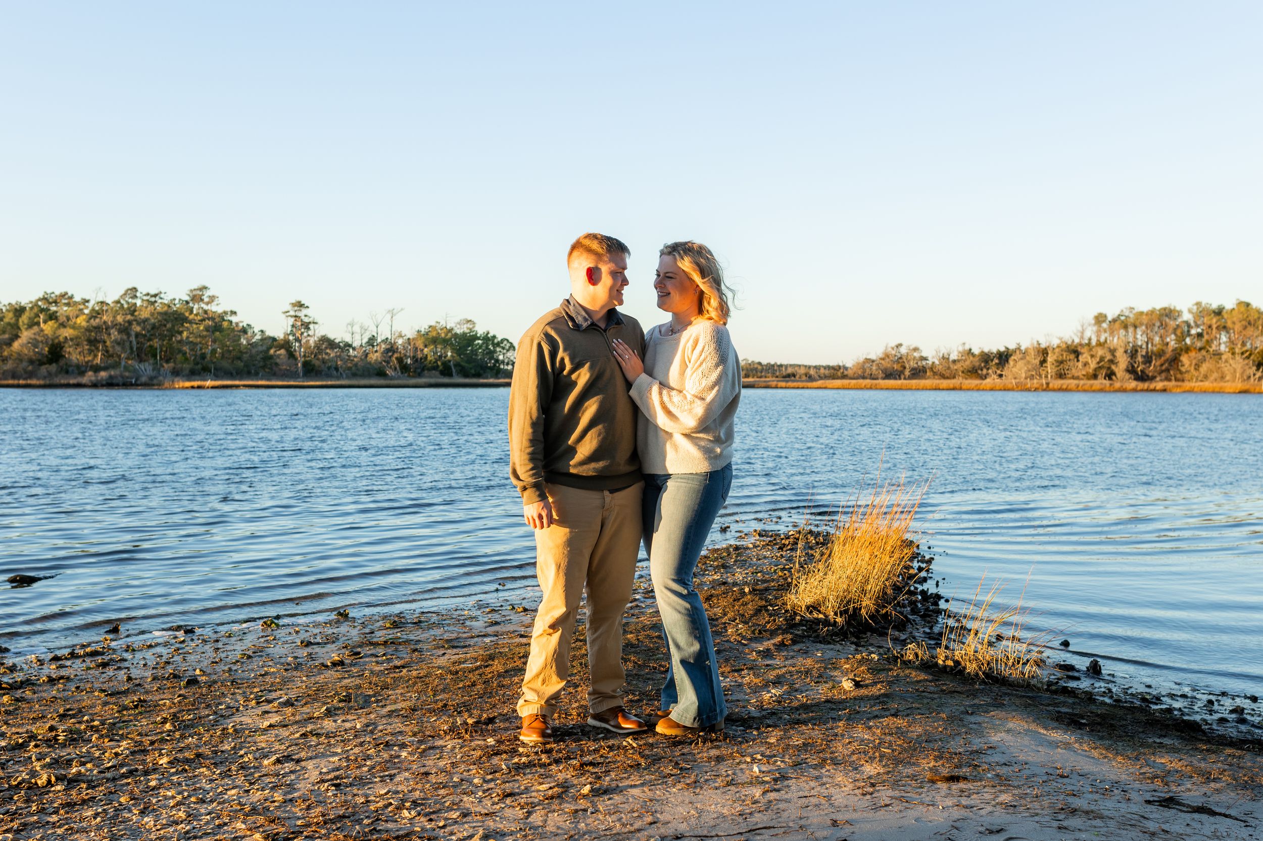 Couple celebrating engagement by the Swansboro waterfront during a Crystal Coast photo session