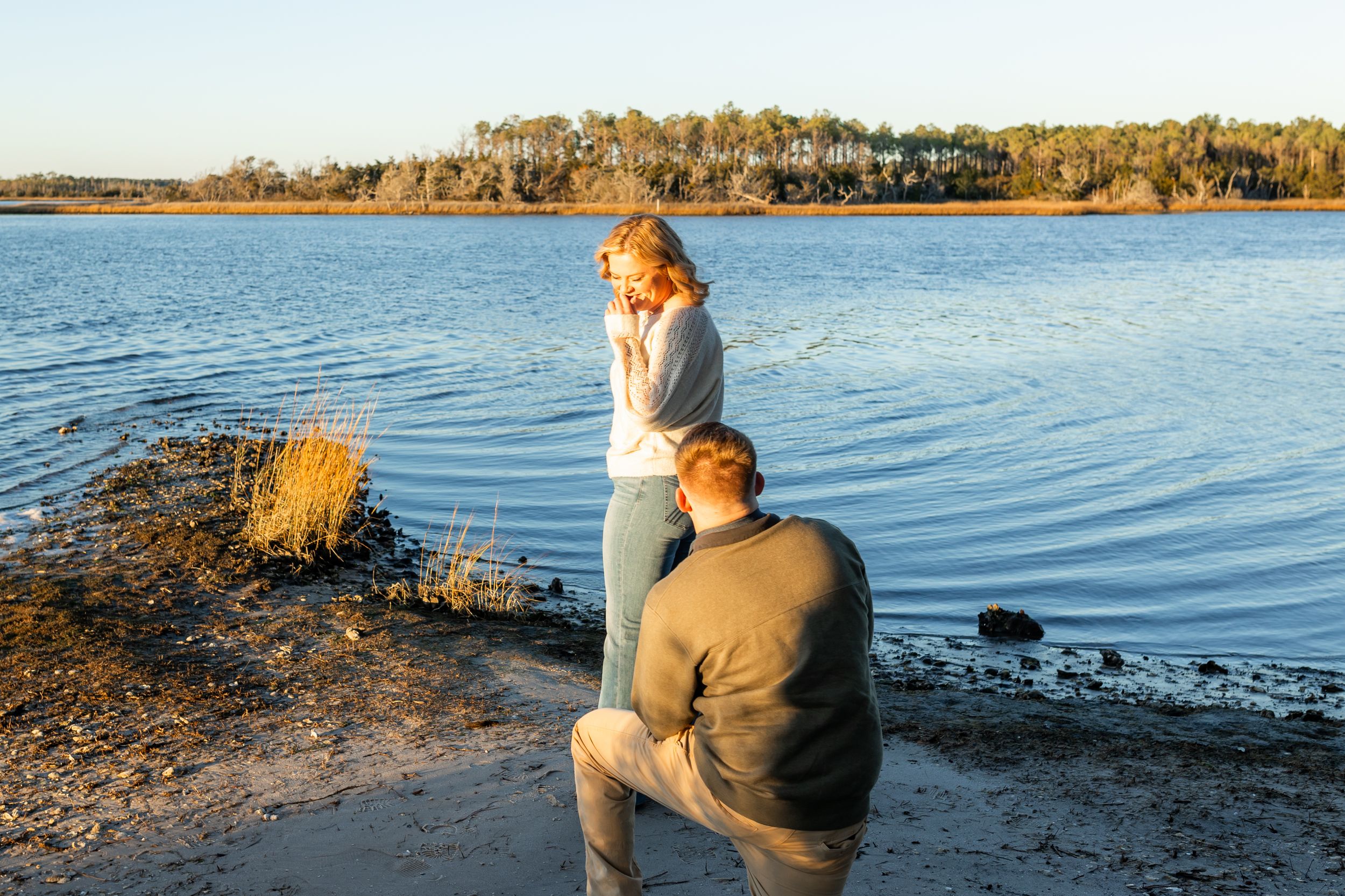 Groom proposing at sunset on Emerald Isle beach, captured by Crystal Coast engagement photographer