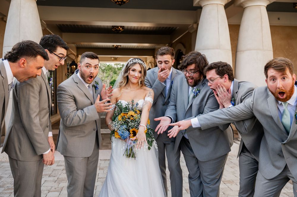 Wedding party shares candid laughing moment together outdoors.