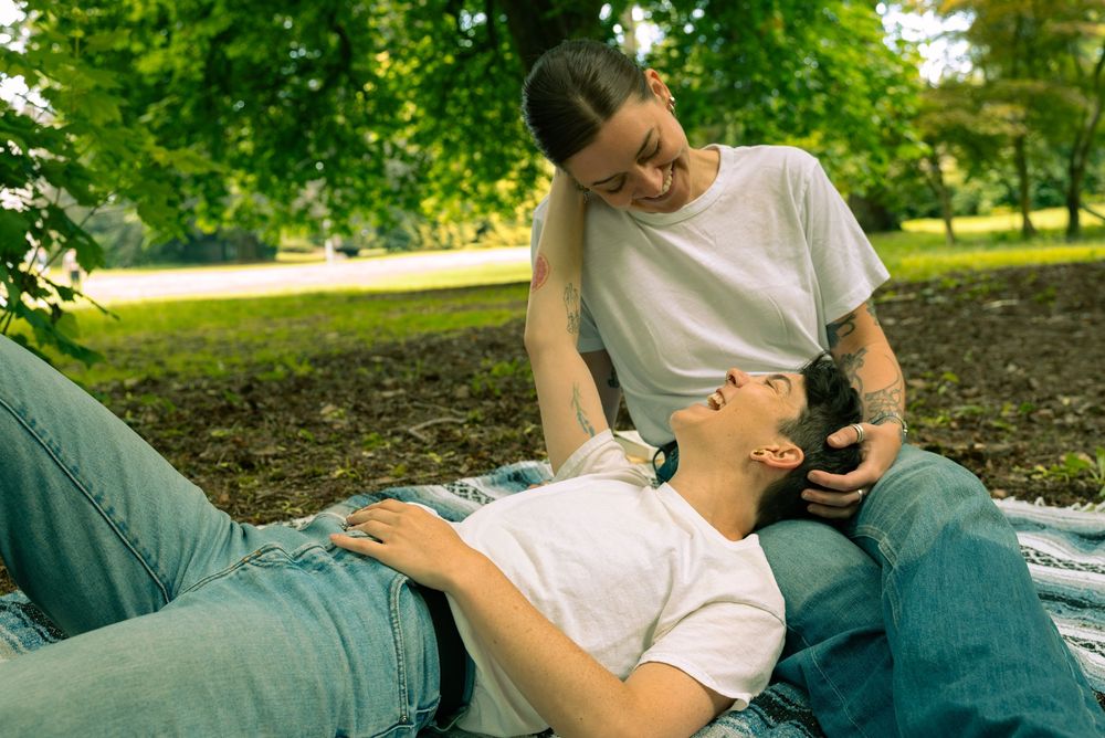 A tender embrace captured in a series of intimate moments on a sunny afternoon in a park.