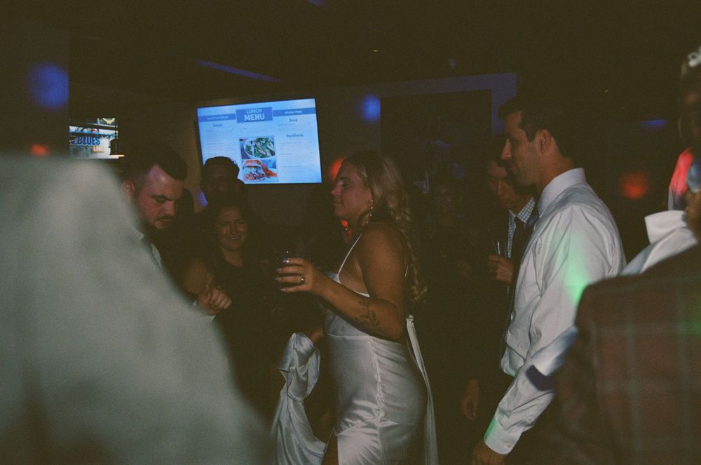 People dancing and socializing at a dimly lit nightclub or party venue.