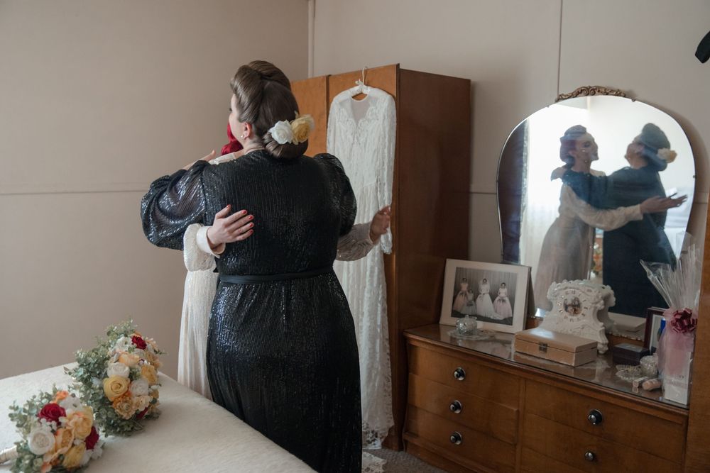 Bride wearing vintage wedding dress sharing a moment with her bridesmaids before her intimate country wedding in rural NSW