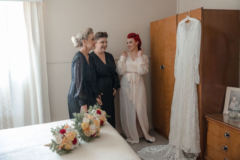 Bride wearing vintage wedding dress sharing a moment with her bridesmaids before her intimate country wedding in rural NSW