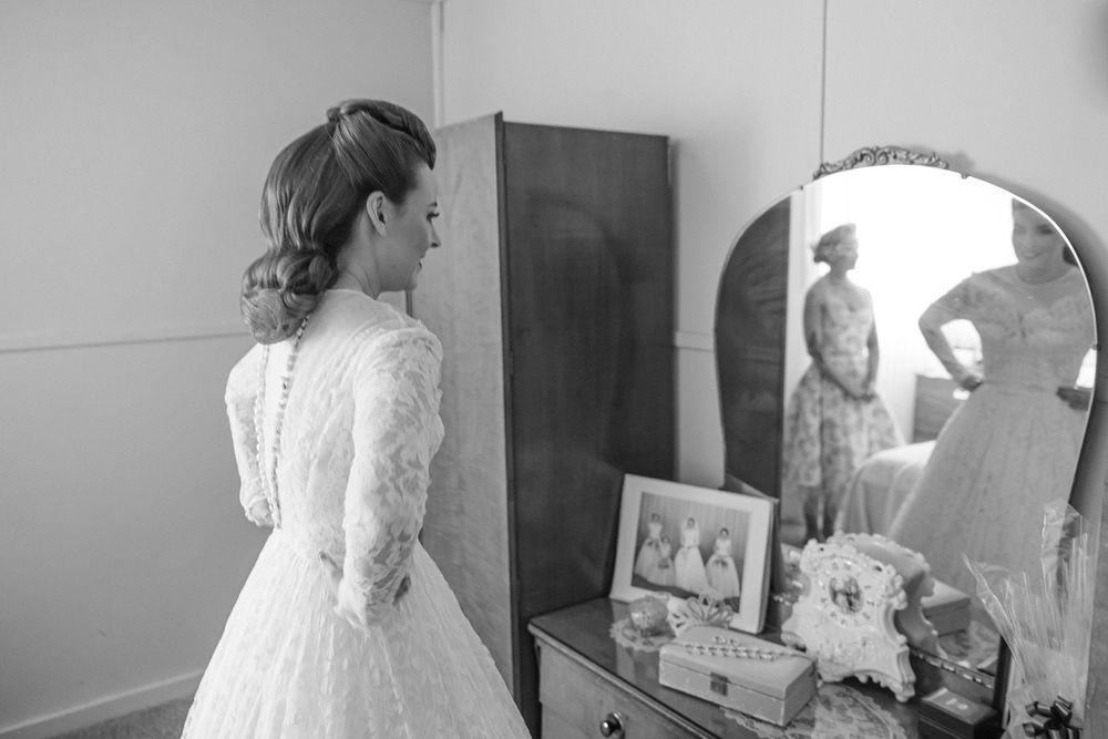 Getting Ready Shot of the Bride in front of a vintage vanity mirror wearing her Grandmother's Wedding Dress