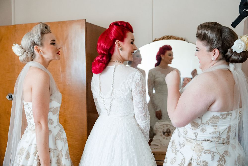 Bride wearing vintage wedding dress sharing a moment with her bridesmaids before her intimate country wedding in rural NSW
