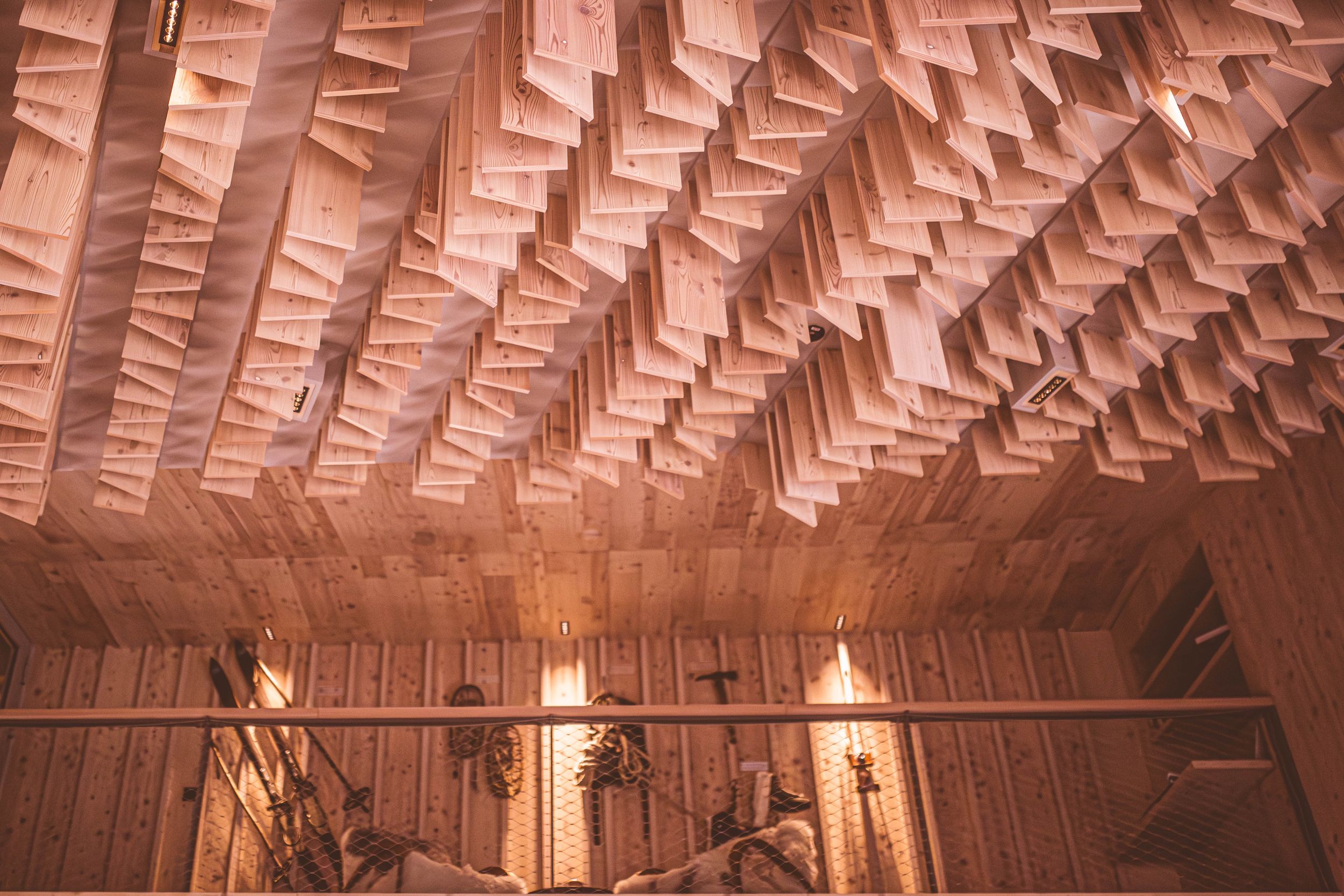 Curved wooden ceiling with intricate geometric patterns and warm lighting creates an architectural focal point.