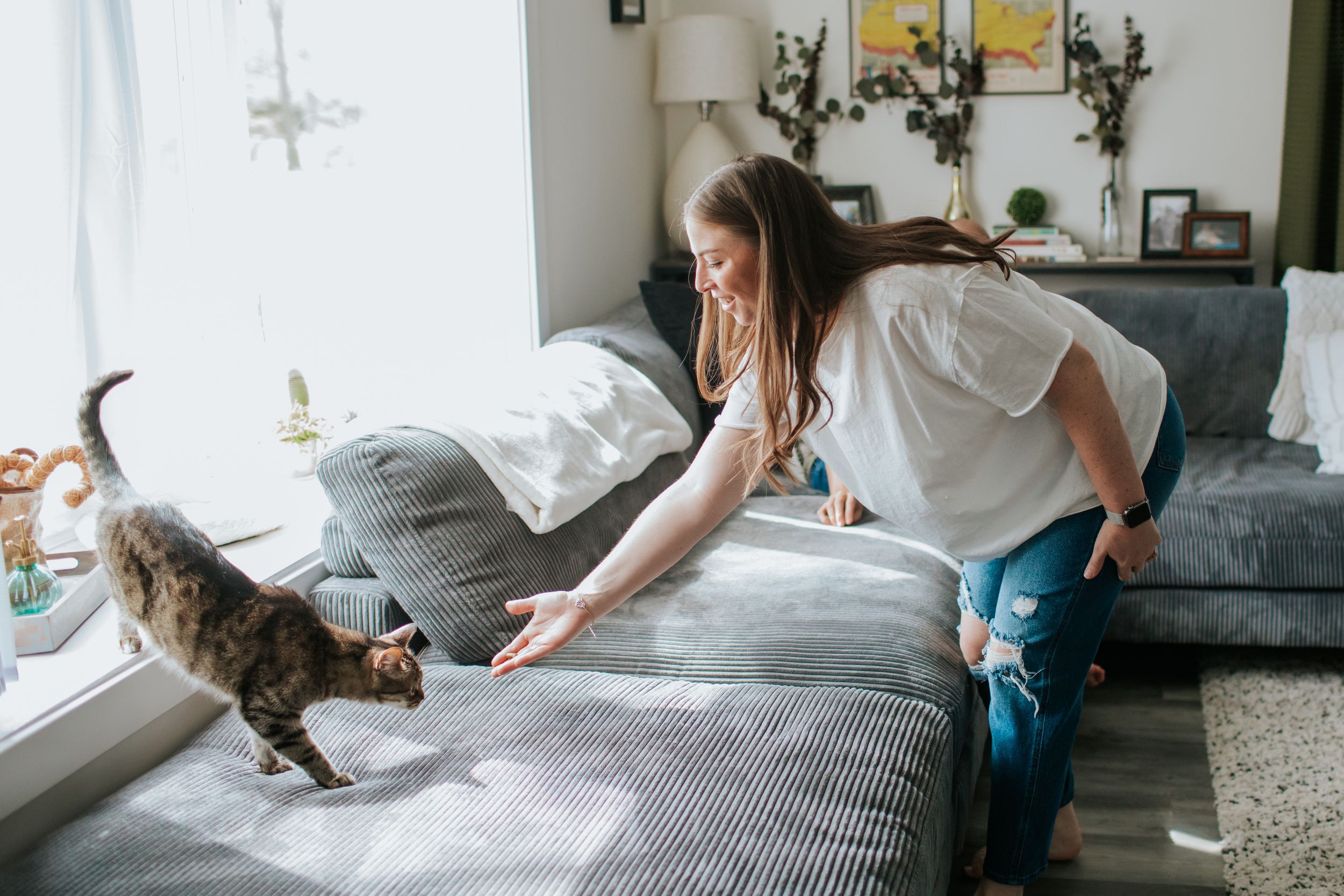 A sequence of photos showing a person making a bed with crisp white linens and pillows in a bright room.