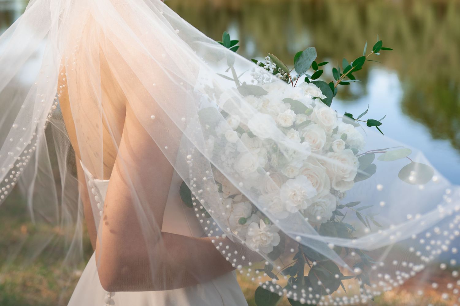 Delicate lace veil detail with soft lighting creates ethereal wedding atmosphere.