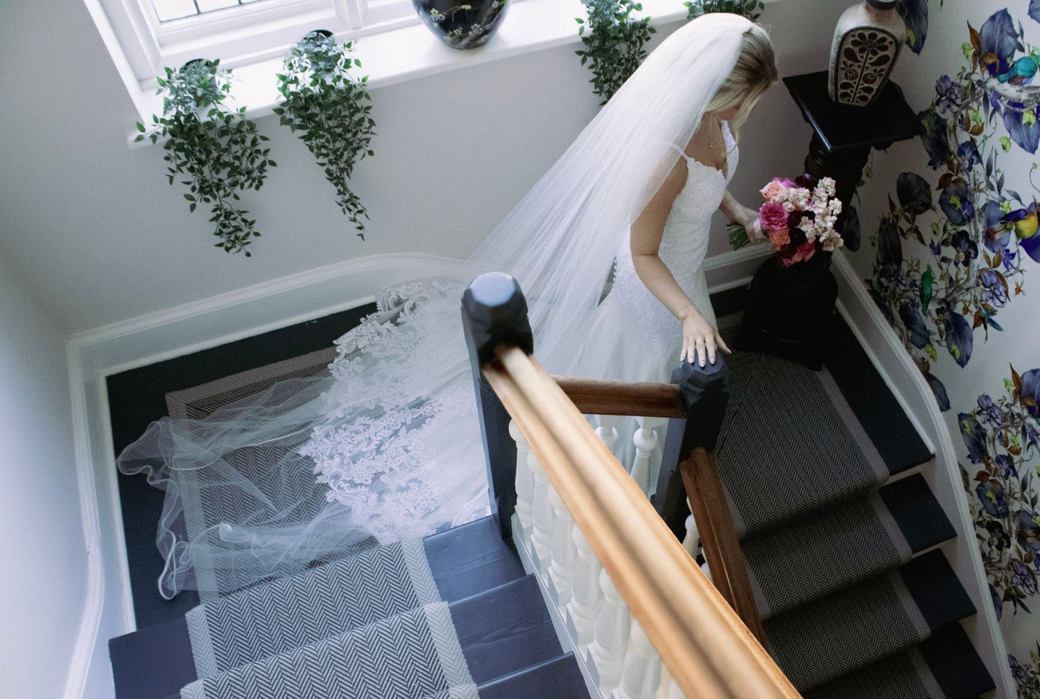 Bride walking down venue staircase in Oxfordshire